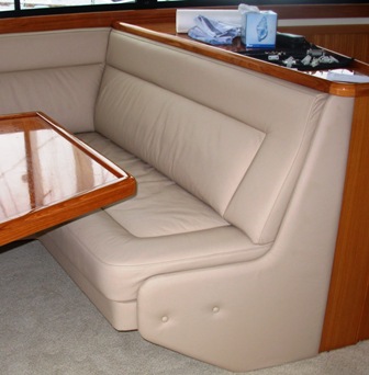 Tailored cream leather seating inside a timber-finished launch